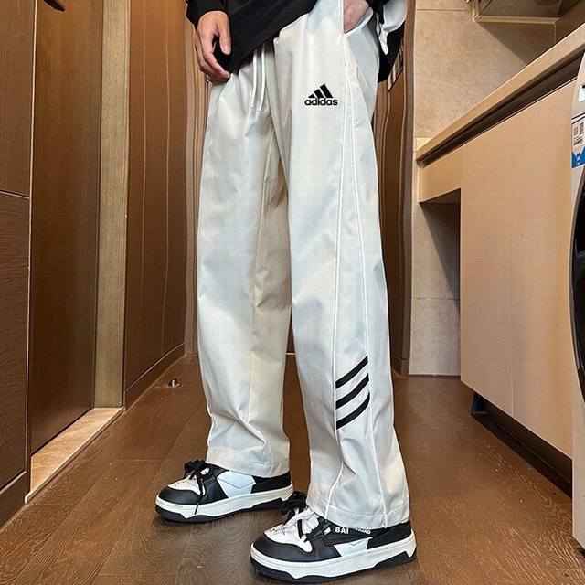 Adidas 阿迪达斯24Ss春季新款拼接防泼阔腿裤休闲直筒情侣款卫裤 优选高密度小牛津面料 质感舒适 防水透气 通勤百搭 舒适无束缚感 侧缝分割设计 修饰腿型